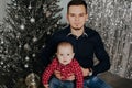 Little boy child in the arms of his father on the background of the Christmas tree Royalty Free Stock Photo