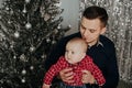Little boy child in the arms of his father on the background of the Christmas tree Royalty Free Stock Photo