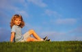 Little boy child with a cute expression face sitting on grass. Cheerful kid having fun on green summer meadow. Copy Royalty Free Stock Photo