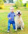 Little boy child and Golden Retriever dog on grass Royalty Free Stock Photo