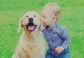 Little child and Golden Retriever dog together on a grass in a park Royalty Free Stock Photo