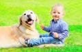 Little boy child and Golden Retriever dog together on the grass in the park Royalty Free Stock Photo