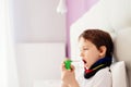 Little boy child inhaling his throat with spray inhaler