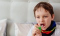 Little boy child inhaling his throat with spray inhaler