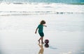 Little boy child play football on coast of sea beach. Summer kids sports. Royalty Free Stock Photo