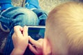 Little boy child playing games on mobile phone outdoor Royalty Free Stock Photo
