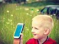 Little boy child playing games on mobile phone outdoor Royalty Free Stock Photo