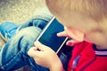 Little boy child playing games on mobile phone outdoor Royalty Free Stock Photo