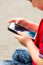 Little boy child playing games on mobile phone outdoor Royalty Free Stock Photo