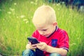 Little boy child playing games on mobile phone outdoor Royalty Free Stock Photo