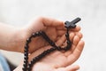 Little boy child praying and holding wooden rosary. Royalty Free Stock Photo