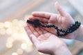 Little boy child praying and holding wooden rosary. Royalty Free Stock Photo