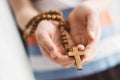 Little boy child praying and holding wooden rosary. Royalty Free Stock Photo