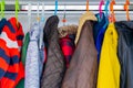 Little boy child size jackets, coats and sweaters hanging in a kid`s closet with colorful hangers Royalty Free Stock Photo