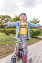 Little boy, child of 3-5 years old, happy to ride bicycle, summer spring autumn day in city park, keeps his balance Royalty Free Stock Photo