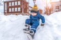 Little boy child 3-5 years old. Sits snow-covered snow drift, skates city park winter. First steps on rink. Free space Royalty Free Stock Photo