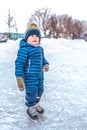 A little boy is a child of 3-5 years old. It is skating in winter in the city park. The first steps on the rink. Free Royalty Free Stock Photo