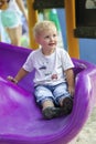 Little boy on a children's slide in the park on a walk Royalty Free Stock Photo