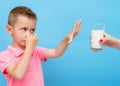 Little kid clamps his nose with his hand and refuses to drink milk Royalty Free Stock Photo