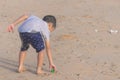 Little boy cleaning up garbage on the beach for enviromental clean up concept