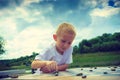 Little boy clever child playing checkers in park Royalty Free Stock Photo