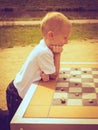 Little boy clever child playing checkers in park Royalty Free Stock Photo