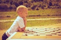 Little boy clever child playing checkers in park Royalty Free Stock Photo