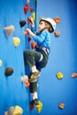 Little boy is climbing on blue wall Royalty Free Stock Photo