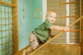 Little boy climbing on indoor wooden slide