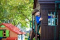 Little boy climbing ladder on slide at playground. Child is 5 7 year age. Caucasian, casual dressed in jeans and pullover. Childre Royalty Free Stock Photo
