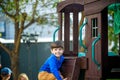 Little boy climbing ladder on slide at playground. Child is 5 7 year age. Caucasian, casual dressed in jeans and pullover. Childre Royalty Free Stock Photo