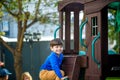 Little boy climbing ladder on slide at playground. Child is 5 7 year age. Caucasian, casual dressed in jeans and pullover. Royalty Free Stock Photo