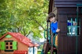 Little boy climbing ladder on slide at playground. Child is 5 7 year age. Caucasian, casual dressed in jeans and pullover. Royalty Free Stock Photo