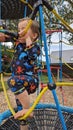 A little boy climbing up a rope ladder climbing frame netting