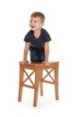 Little boy climbing up stool on background. Danger at home Royalty Free Stock Photo