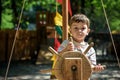 Little boy climbing on a wooden playground in rope park. Kid play outdoors warm sunny summer day Royalty Free Stock Photo