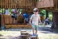 Little boy climbing on a wooden playground in rope park. Kid play outdoors warm sunny summer day Royalty Free Stock Photo