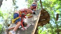 Little boy climbs the climbing wall by rearranging the carabiners