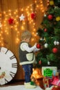 Little boy with a clock and gifts at the Christmas tree Royalty Free Stock Photo