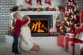 A little boy closed his mother`s eyes, surprise. Christmas presents under the tree.Merry Christmas and Happy Holidays! Royalty Free Stock Photo