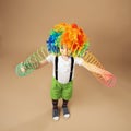 Little boy in clown wig playing with a spring