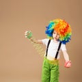 Little boy in clown wig smilling and playing with Magic Spring