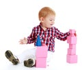 Little boy collects pink pyramid. Royalty Free Stock Photo