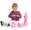 Little boy collects pink pyramid. Royalty Free Stock Photo