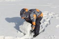 The little boy in a color jacket with a hood rolling a snowball