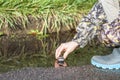 Little boy in colored rubber boots playing with his toy car in the puddle