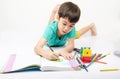 Little boy coloring image lay on the floor in concentrate Royalty Free Stock Photo