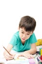 Little boy coloring image lay on the floor in concentrate Royalty Free Stock Photo