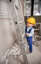 Little boy climbing ladder in apartment under renovation. Royalty Free Stock Photo