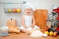 Little boy in the cook costume at the kitchen with bread